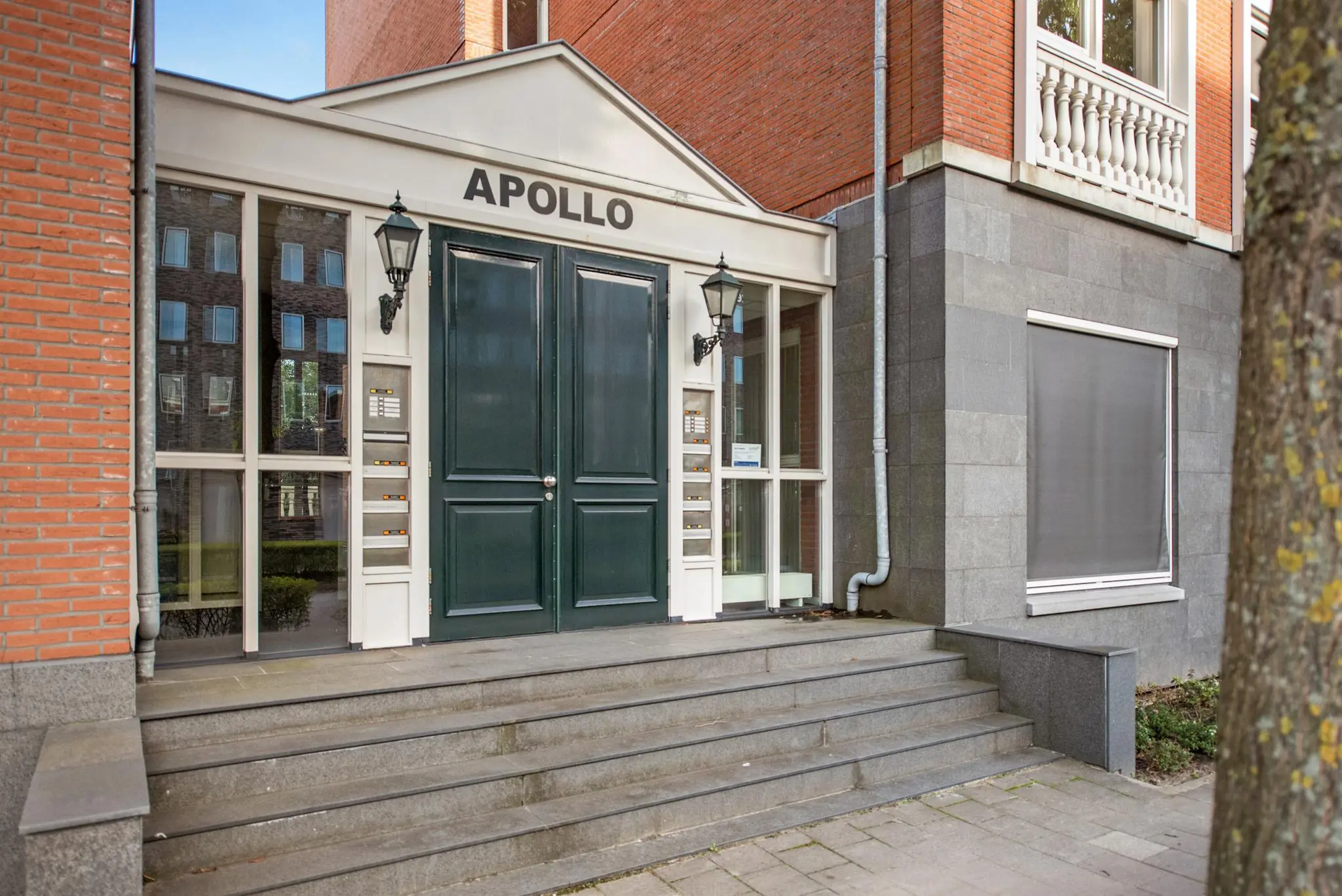 Ingang van het appartementengebouw Apollo aan de Laan van Vredenoord, met een dubbele voordeur en trap.